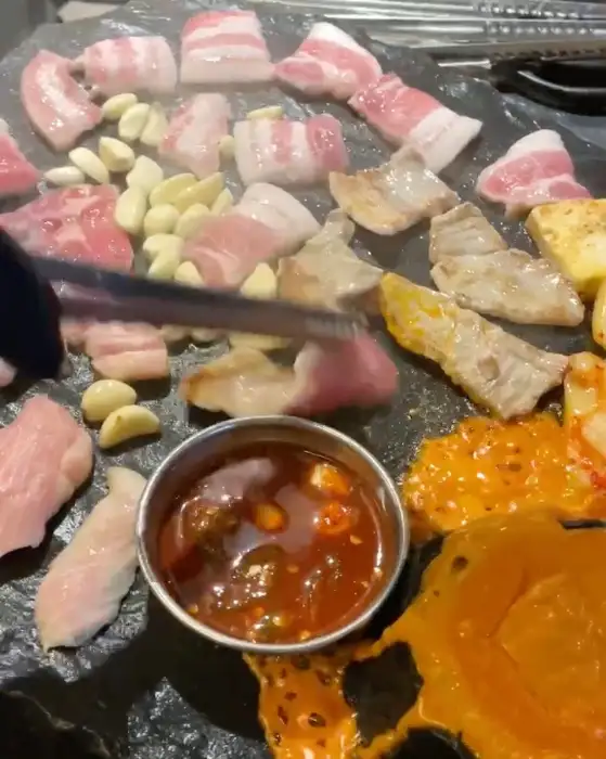 돌판 위에서 익어가는 고기와 마늘