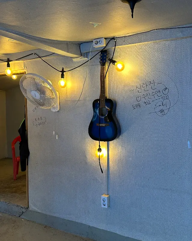벽에 걸린 기타와 조명