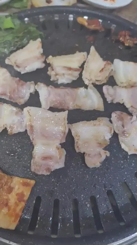 불판 위에서 노릇노릇 익어가는 삼겹살