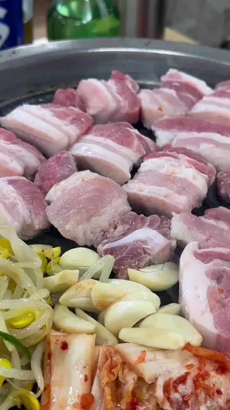 삼겹살과 김치, 콩나물이 함께 구워지는 모습