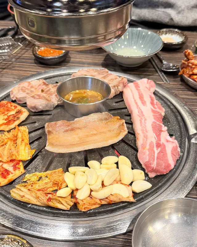 숯불 위에서 익어가는 삼겹살과 김치의 조화