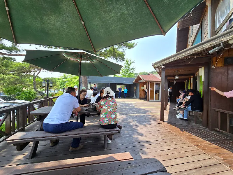 넓은 나무 테이블과 야외 좌석이 있는 북한강쭈꾸미 식당 외부