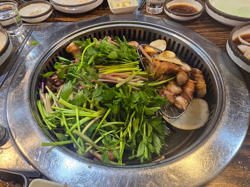 불판 가득 구워진 삼겹살과 미나리