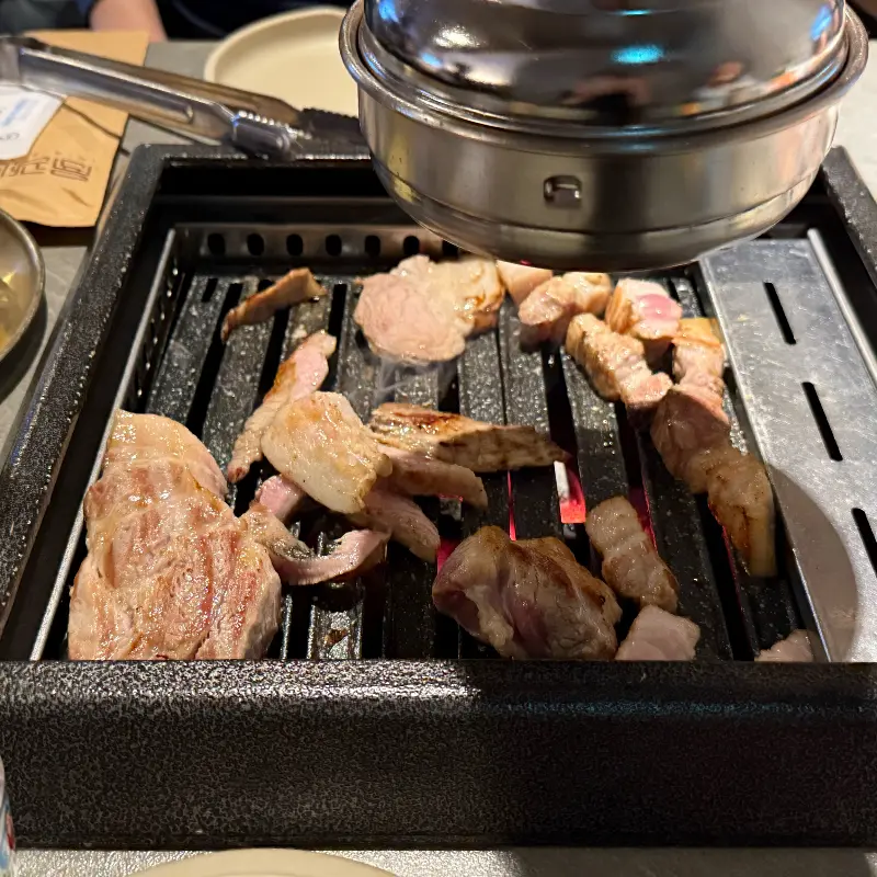 불판 위에서 지글지글 익어가는 돼지고기 모듬