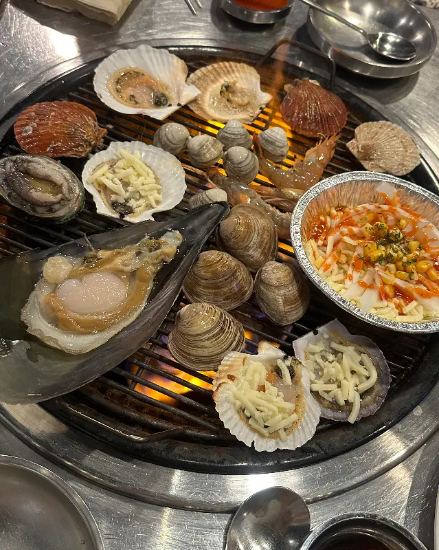 불판 가득 채운 조개와 해산물