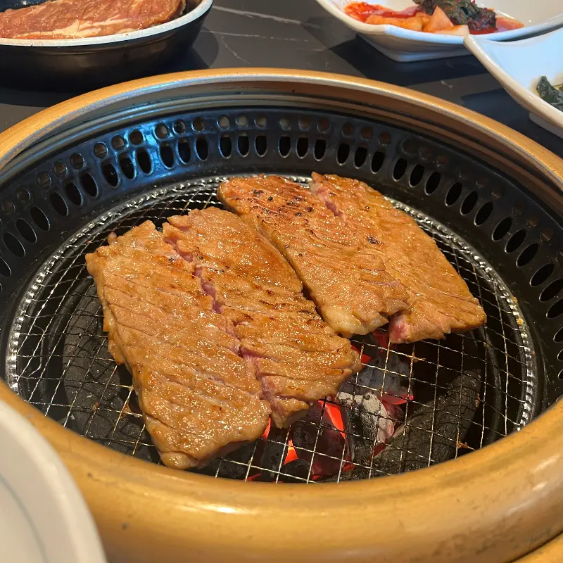 숯불 위에서 노릇하게 구워지고 있는 돼지갈비