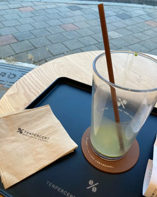 텐퍼센트의 음료와 냅킨, 코스터가 놓인 테이블