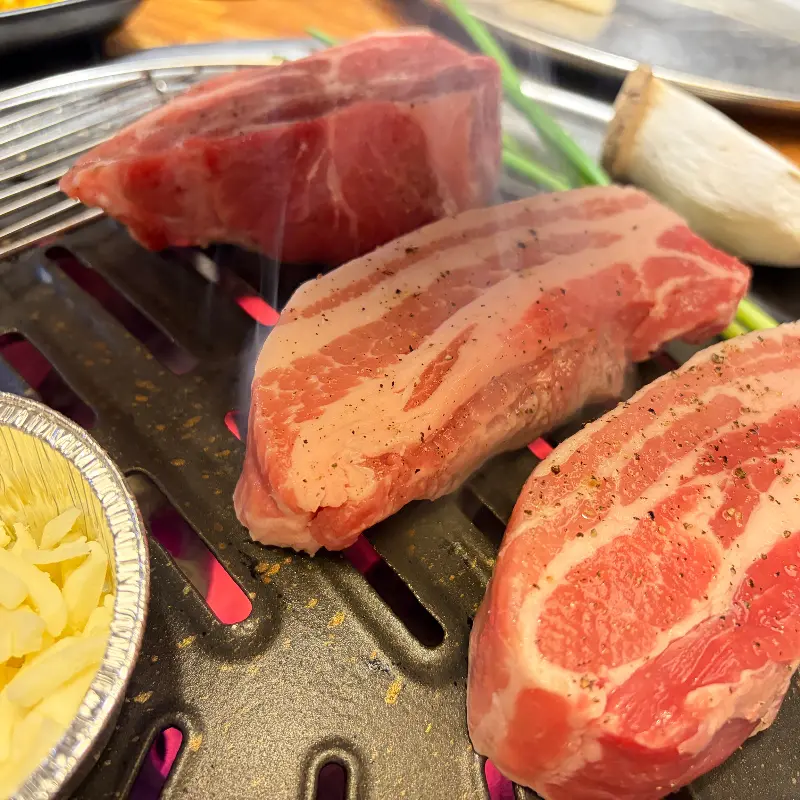 숯불 위에 올려진 삼겹살과 목살