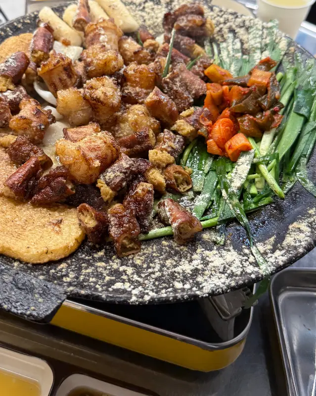 불판 위에 놓인 마늘 곱창 구이