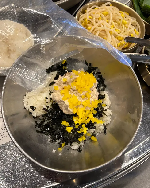 밥 위에 김가루, 단무지, 마요네즈 소스가 올려진 볶음밥 재료