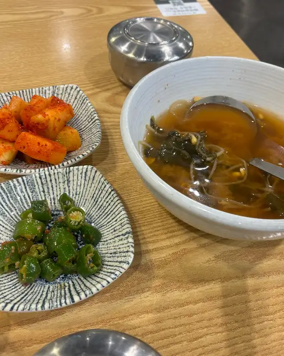 따뜻한 국물 요리와 함께 여러 가지 밑반찬들이 차려진 모습. 정갈하고 맛깔스러운 반찬들이 밥상을 풍성하게 채운다.