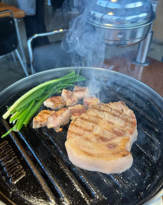 불판 위에서 익어가는 목살과 꽈리꼬추.