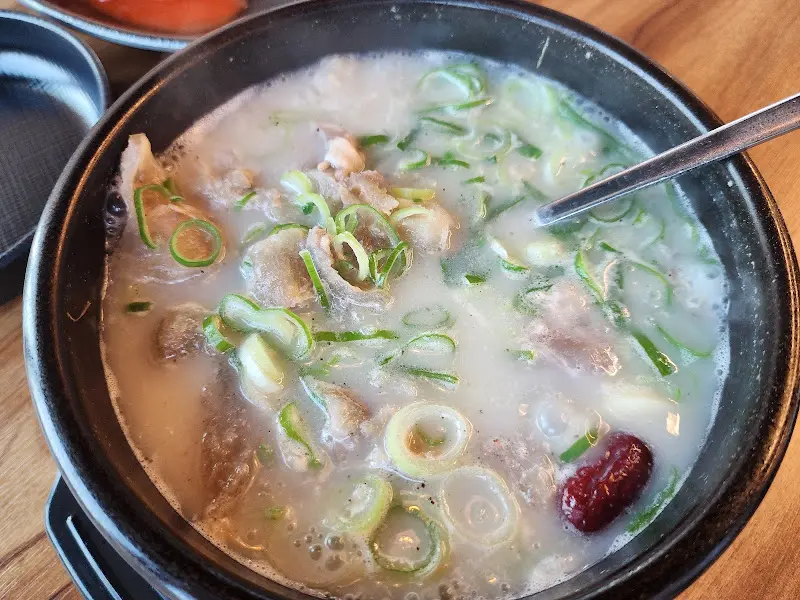 설렁탕에 밥을 말아 한 숟갈 크게 뜨는 모습