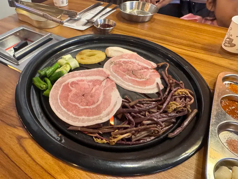 불판에 올려진 꽃삼겹살과 고사리