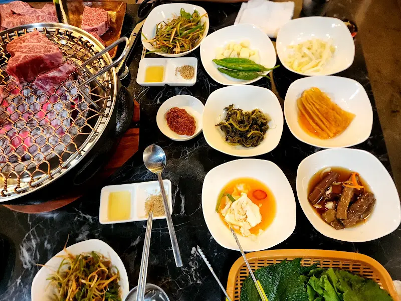 한 상 가득 차려진 밑반찬과 숯불 구이