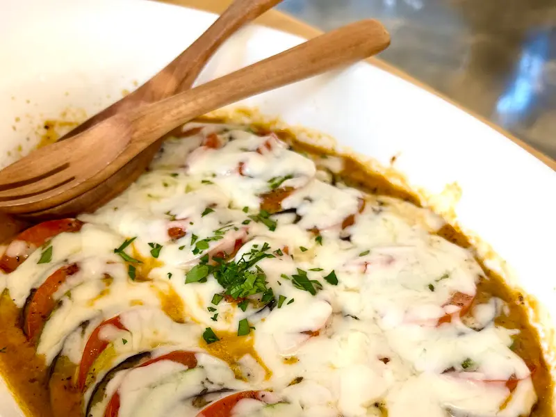 층층이 쌓인 채소 위에 치즈가 듬뿍 얹어진 라따뚜이의 모습