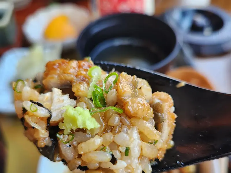 히츠마부시를 숟가락에 올려 한 입 가득 먹는 모습