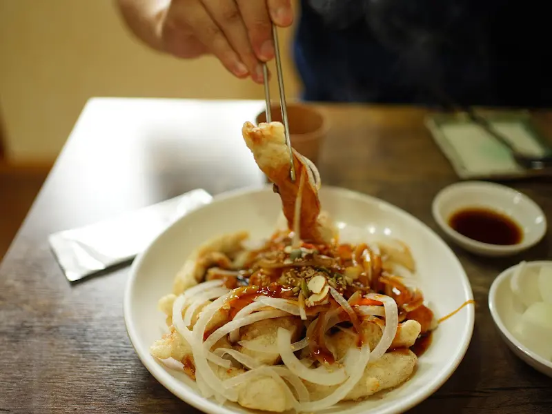 젓가락으로 탕수육을 집는 모습