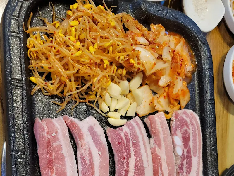 불판 위의 삼겹살, 김치, 콩나물, 마늘