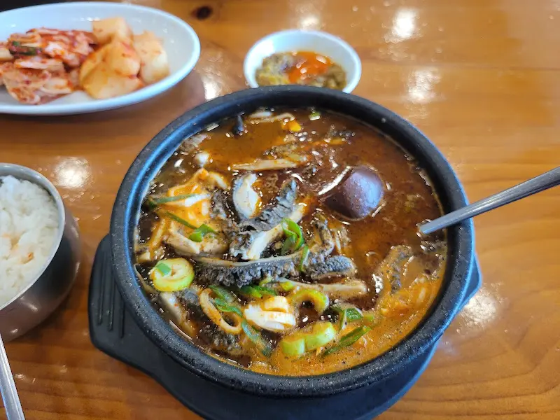 테이블 위에 놓인 양평해장국 특 사이즈 뚝배기와 반찬 그릇들의 모습