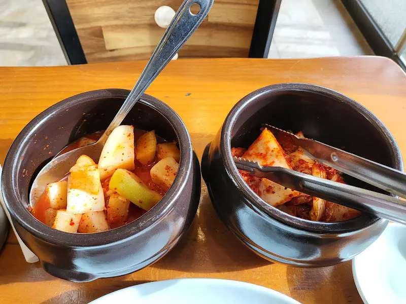 테이블 위에 놓인 깍두기와 김치의 모습