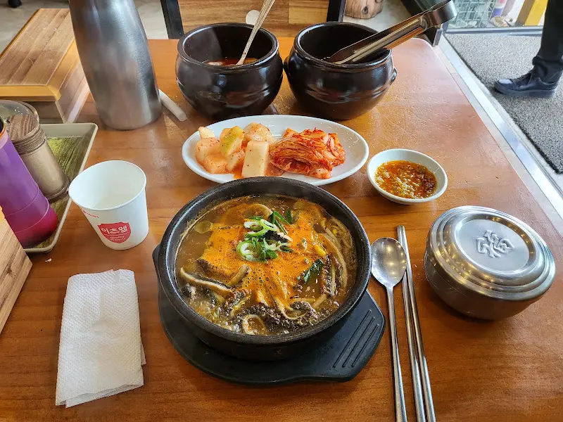 해장국과 김치, 깍두기, 고추기름 등이 놓인 테이블 전체 샷