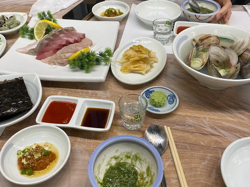 한 상 가득 차려진 회와 곁들임 반찬