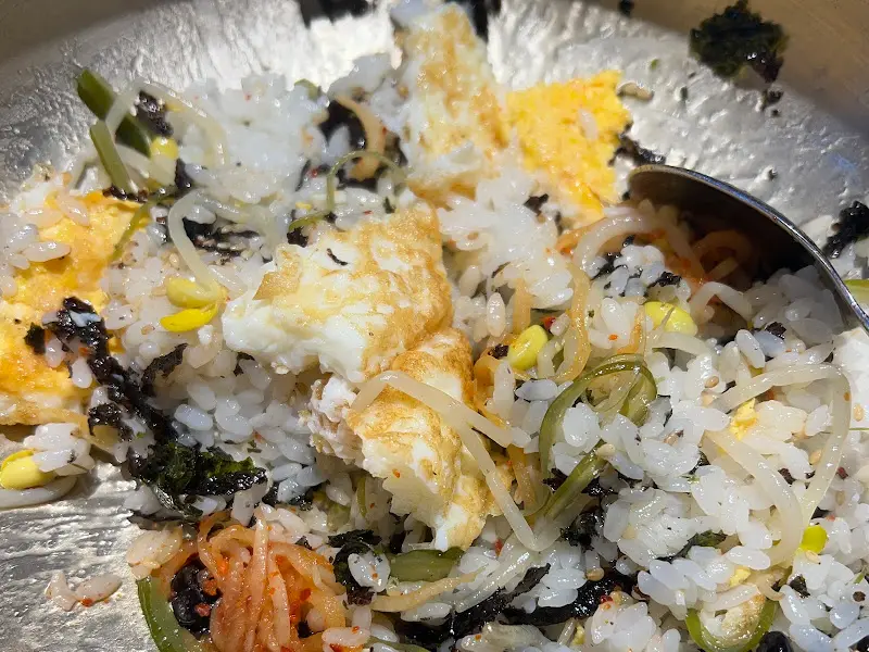 솥밥에 각종 반찬을 넣어 비벼 먹는 모습