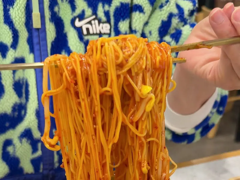 젓가락으로 비빔국수를 들어올리는 모습