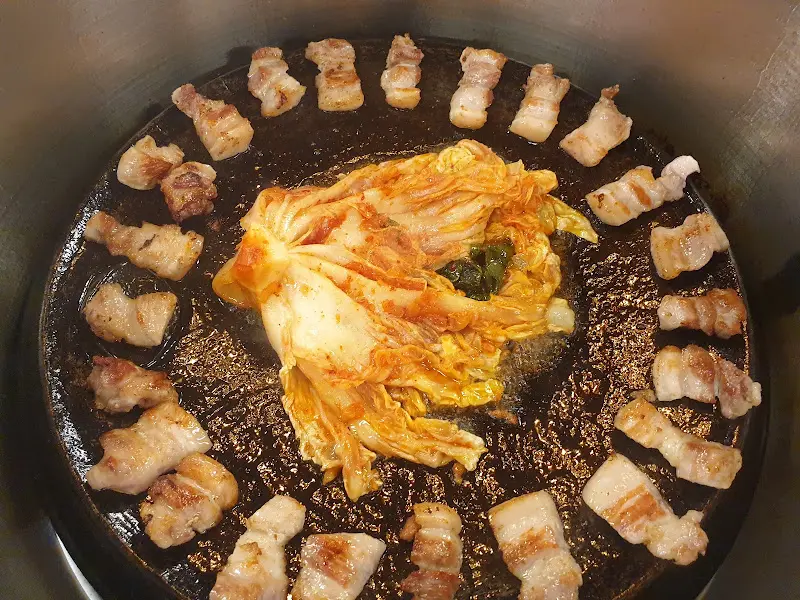 무쇠판에 구워진 삼겹살과 김치의 환상적인 비주얼