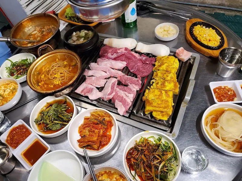 연탄불 위에 푸짐하게 차려진 고기 한 상