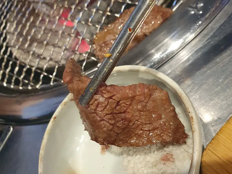 잘 익은 갈비살을 소스에 찍어 먹는 모습