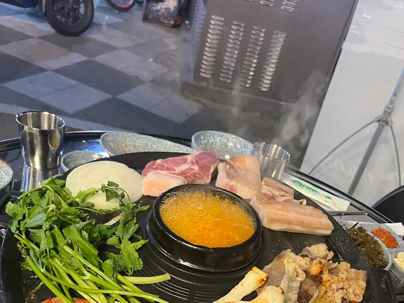 야외 테이블에서 고기를 구워먹는 모습