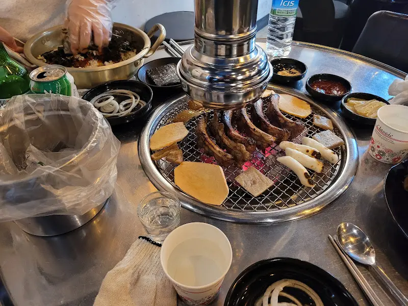 불판 위에 쪽갈비와 함께 구워지는 떡과 돼지 껍데기