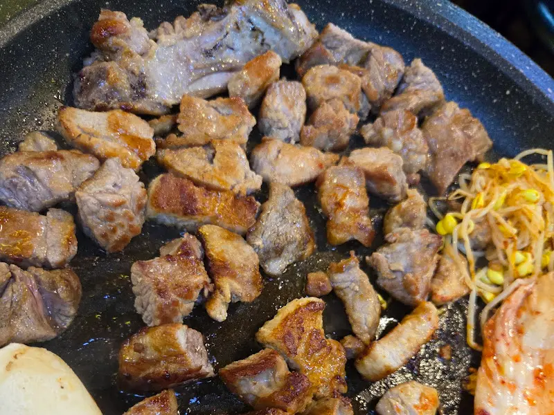 돌판 위에서 노릇하게 구워지고 있는 돼지고기