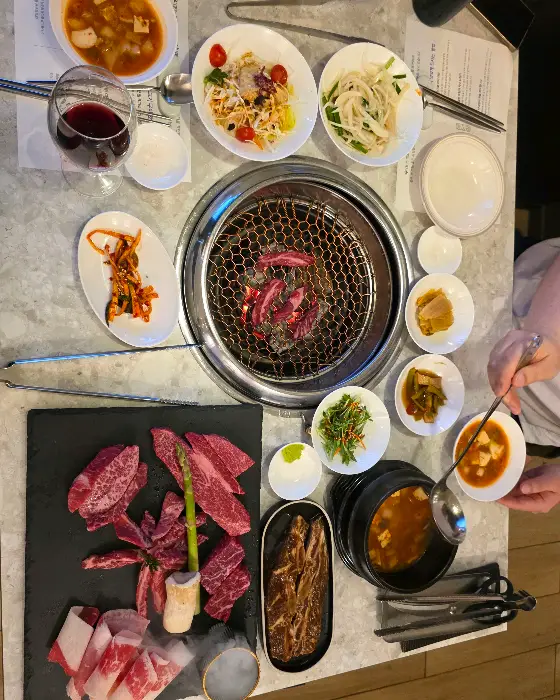 테이블 위 숯불 화로와 함께 차려진 푸짐한 식사