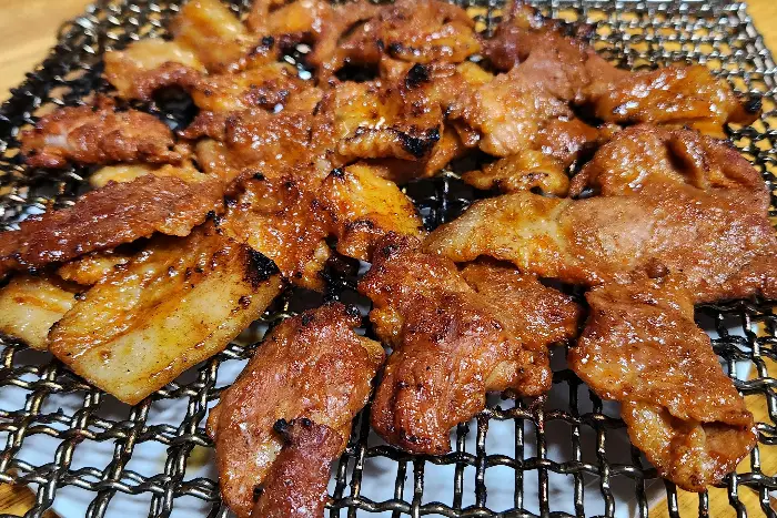 불판 위에서 노릇하게 구워지는 양념 석쇠구이