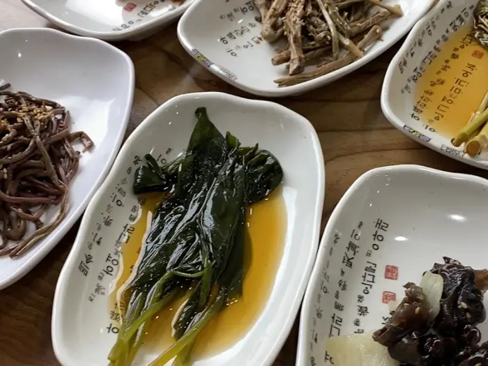 접시에 담긴 푸른 잎 채소와 소스가 어우러진 모습