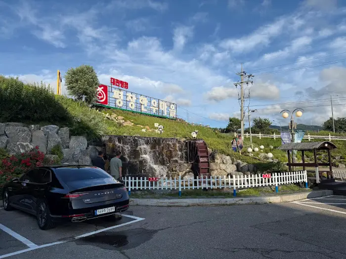 평창한우마을 주변 풍경, 인공 폭포와 조경이 보입니다.