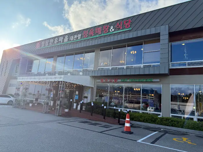 평창한우마을 건물 전면 모습, 큰 유리창이 특징입니다.