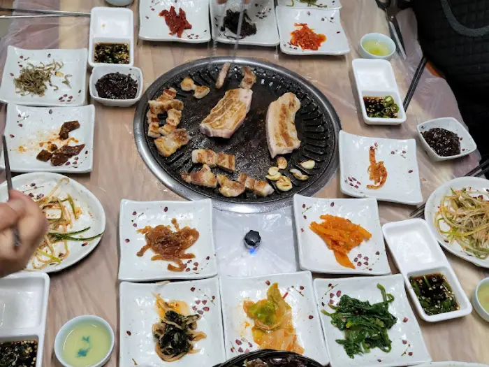 푸짐하게 차려진 삼겹살 구이와 다양한 반찬