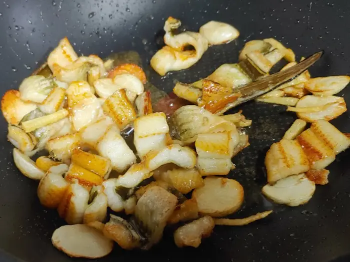 프라이팬에 볶아지고 있는 얇게 썰린 재료들