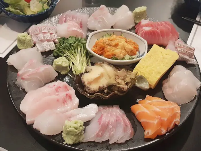 다양한 종류의 신선한 사시미와 곁들임 찬이 플레이팅된 모습