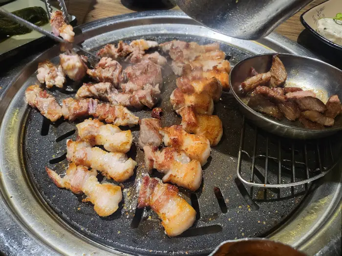 불판 위에서 노릇하게 구워지는 삼겹살과 목살