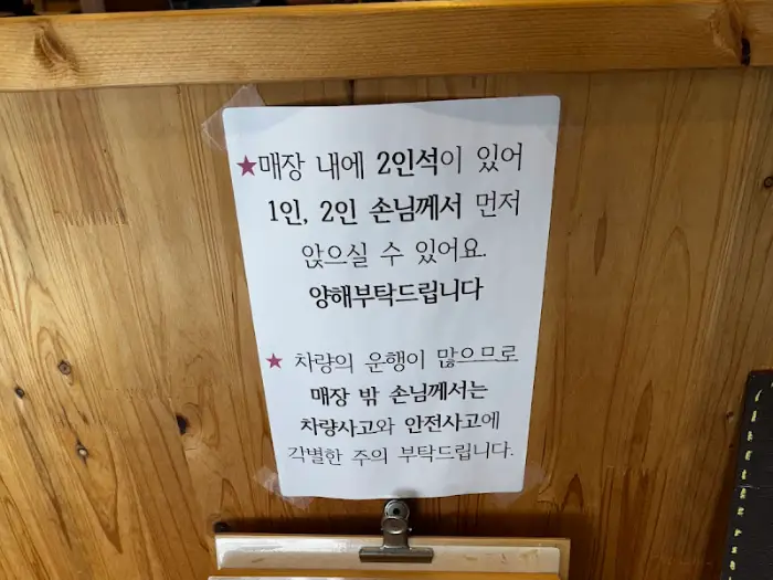 나무 벽에 붙어있는 안내문