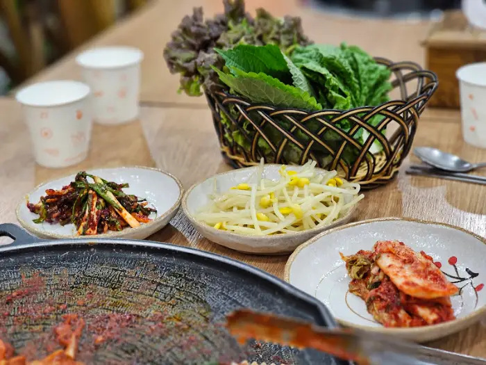 다양한 밑반찬과 쌈 채소가 놓여있는 식탁 모습.