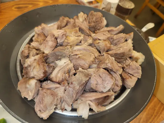 양이 푸짐한 수육이 담긴 원형 팬