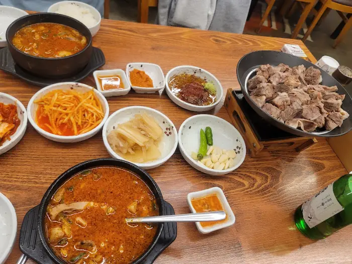 테이블 위에 차려진 푸짐한 한상차림, 순대국, 수육, 반찬들