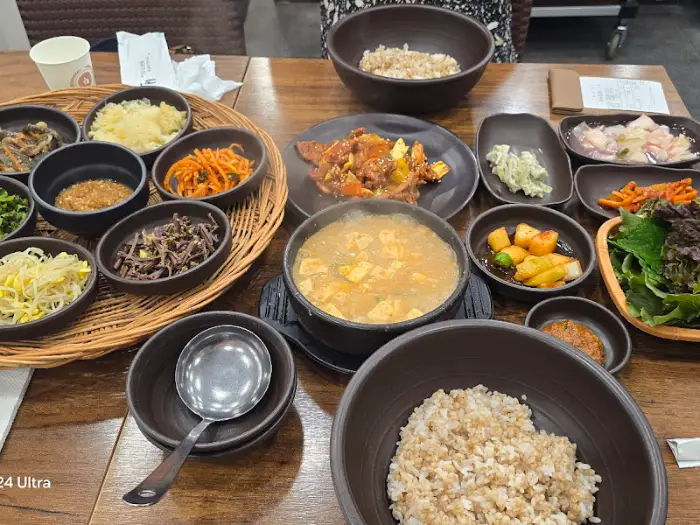 보글보글 끓는 청국장 뚝배기와 밥, 나물 반찬들.