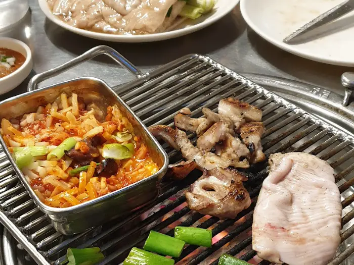 김치찌개와 함께 불판 위 고기가 익어가는 모습